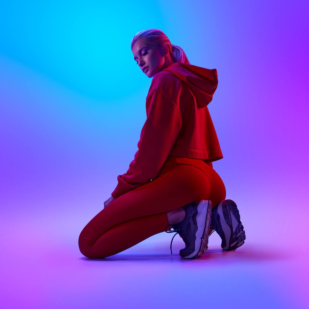 Ruslana Agafonova, sesión de fotos de estudio con iluminación de neón violeta y azul.